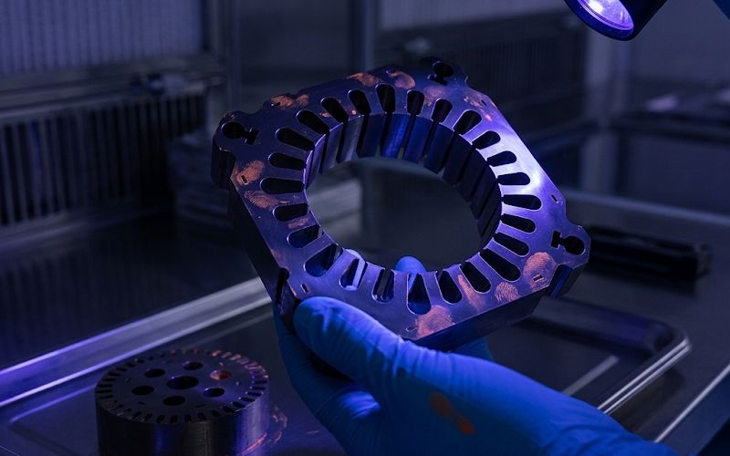 Ultraviolet inspection revealing hidden lubricant residue on a stamped electrical steel lamination